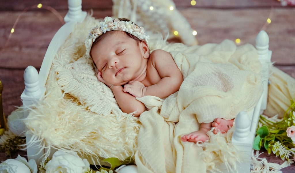 Красивая новорожденная девушка с венком на голове 