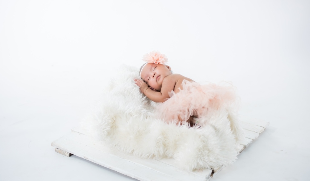 Милая спящая девочка в розовой юбке 