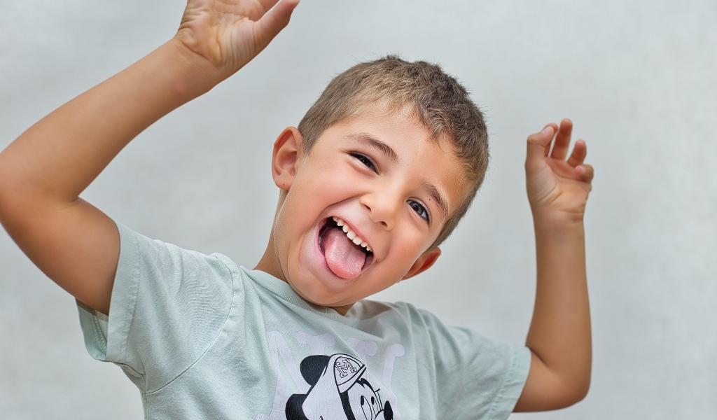 Смешной мальчик высунул язык