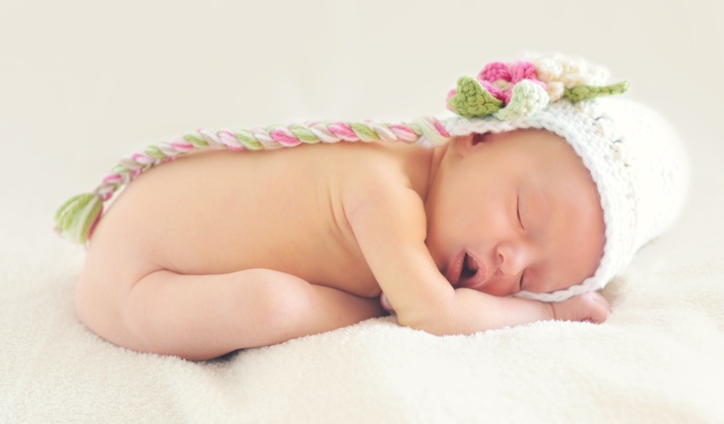 Нежный спящий ребенок в вязаной шапке 