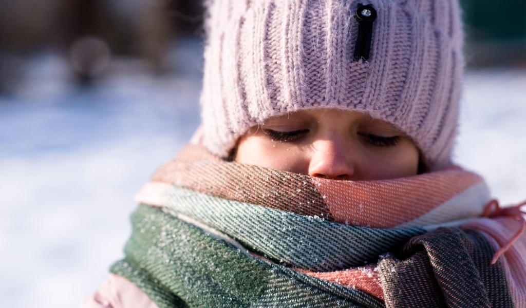 Девочка в теплой вязаной шапке зимой