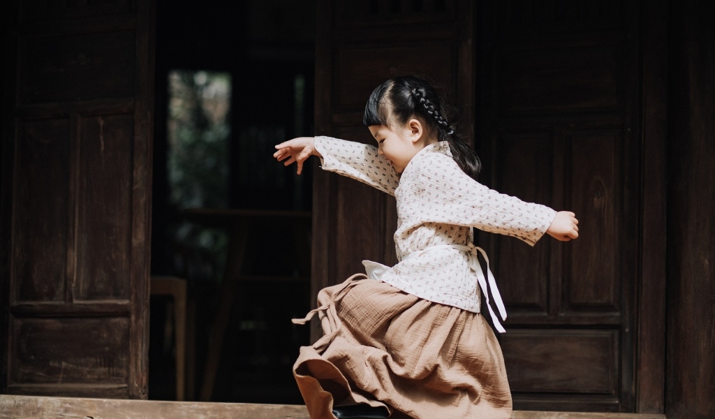 Маленькая девочка азиатка танцует