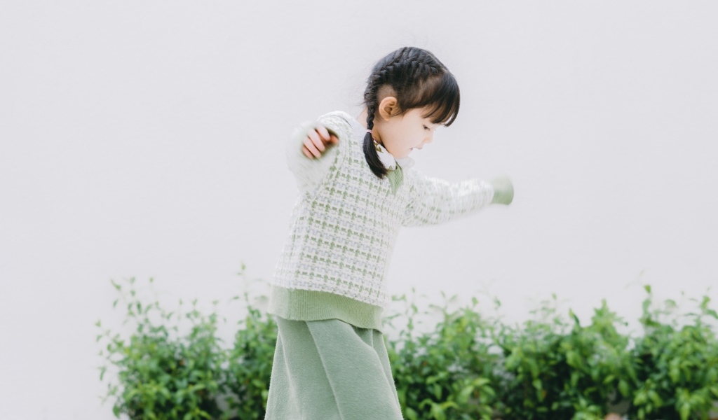 Маленькая девочка азиатка играет в саду