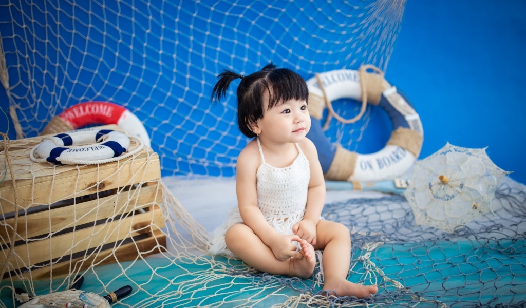 Маленькая девочка азиатка со  спасательным кругом и сетью 