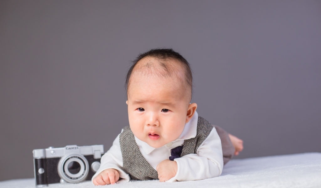 Маленький мальчик в костюме с фотоаппаратом