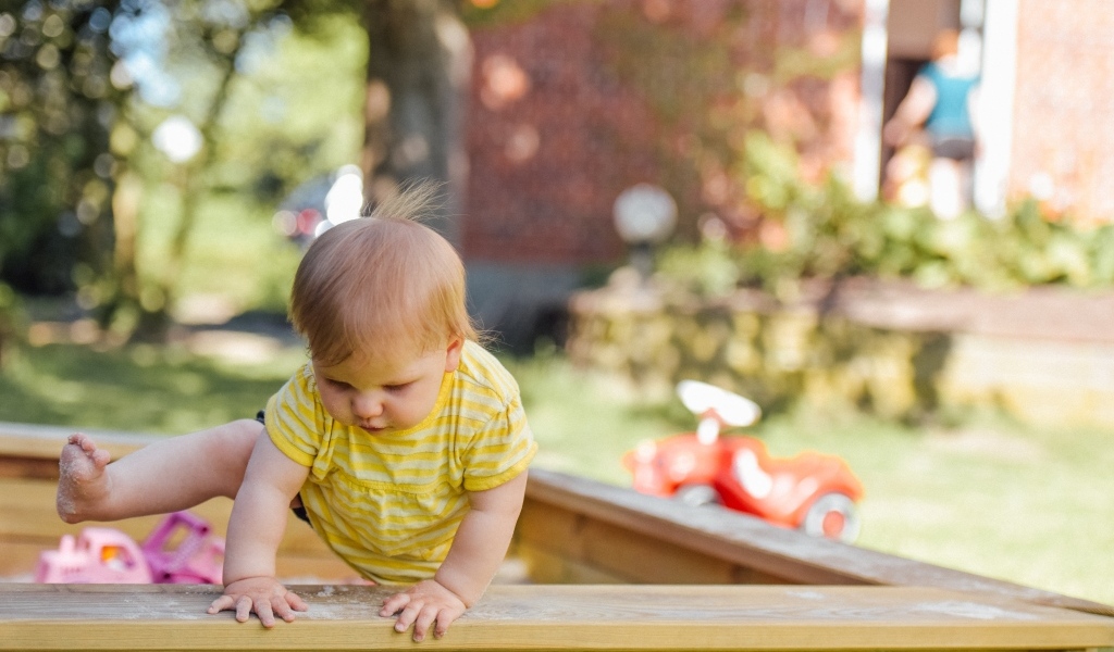 Маленький мальчик играет в песочнице