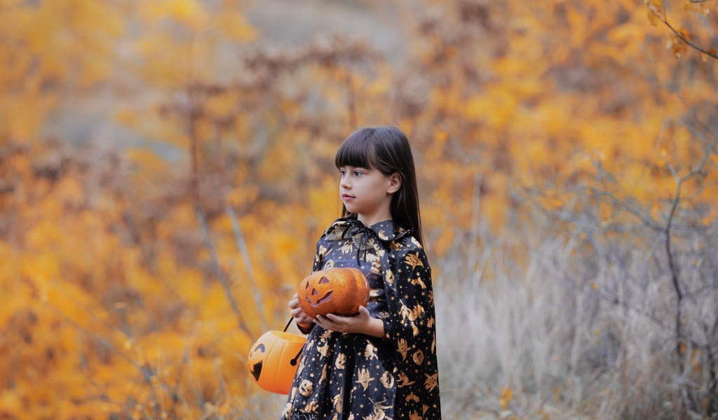 Маленькая девочка с тыквой в руках