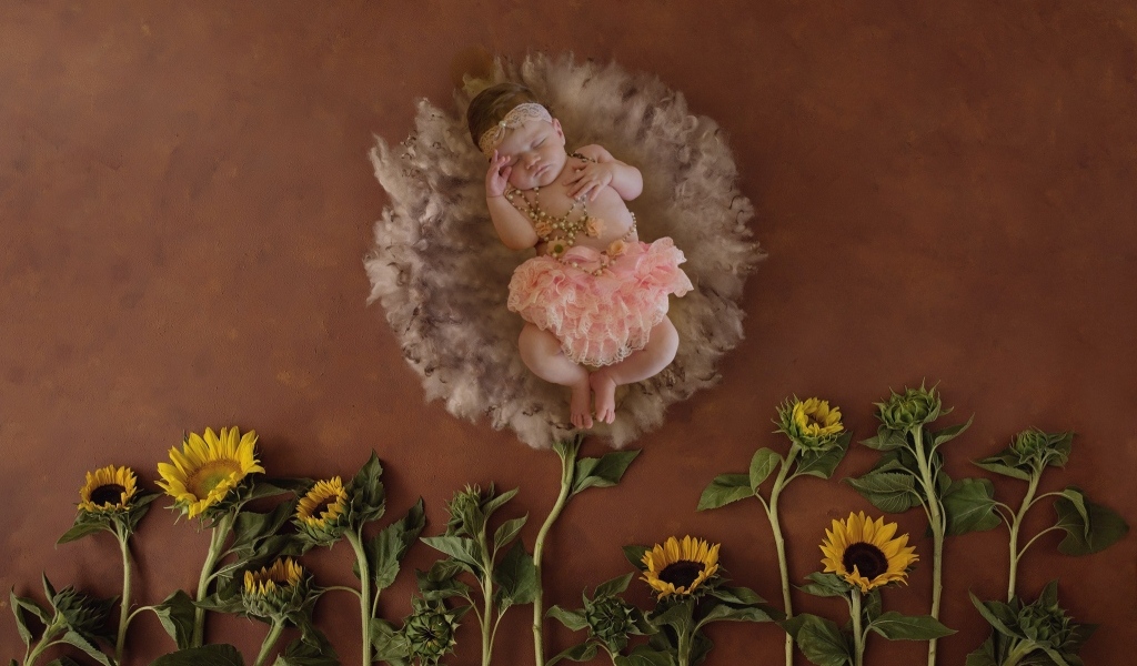 Маленькая девочка с цветами подсолнуха