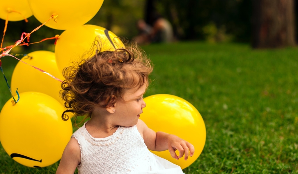 Маленькая девочка с желтыми шариками