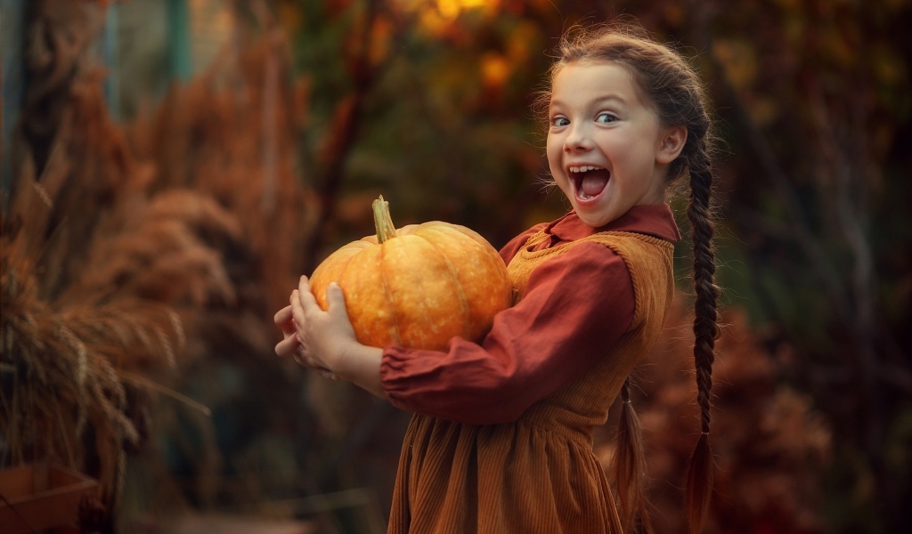 Маленькая рыжеволосая девочка с тыквой