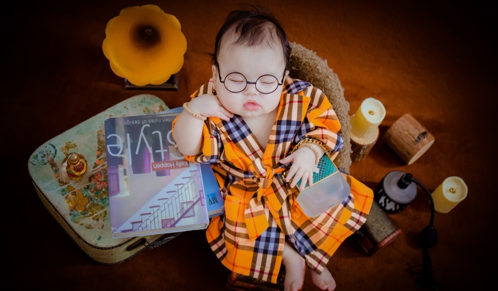 Маленький спящий ребенок в очках и халате