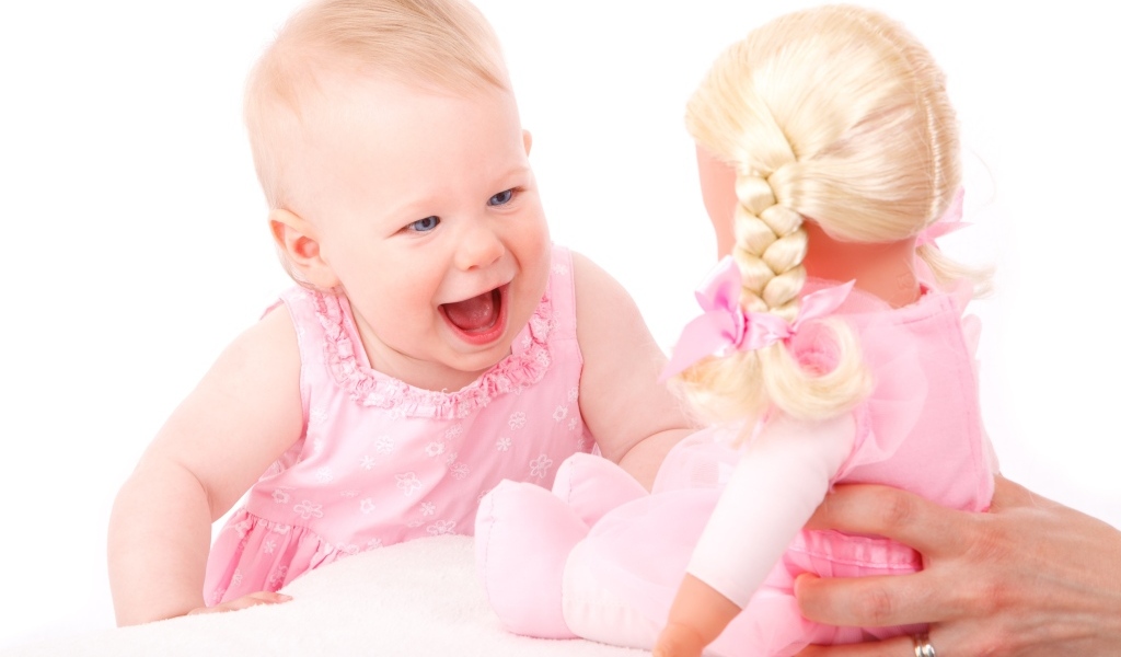 Маленькая улыбающаяся девочка с куклой