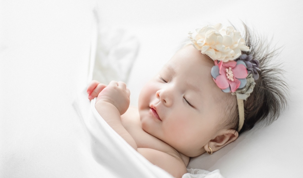 Новорожденная девочка с повязкой на голове