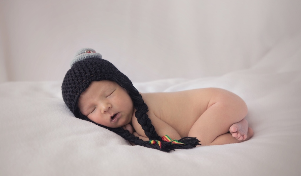 Новорожденная кроха в черной шапке
