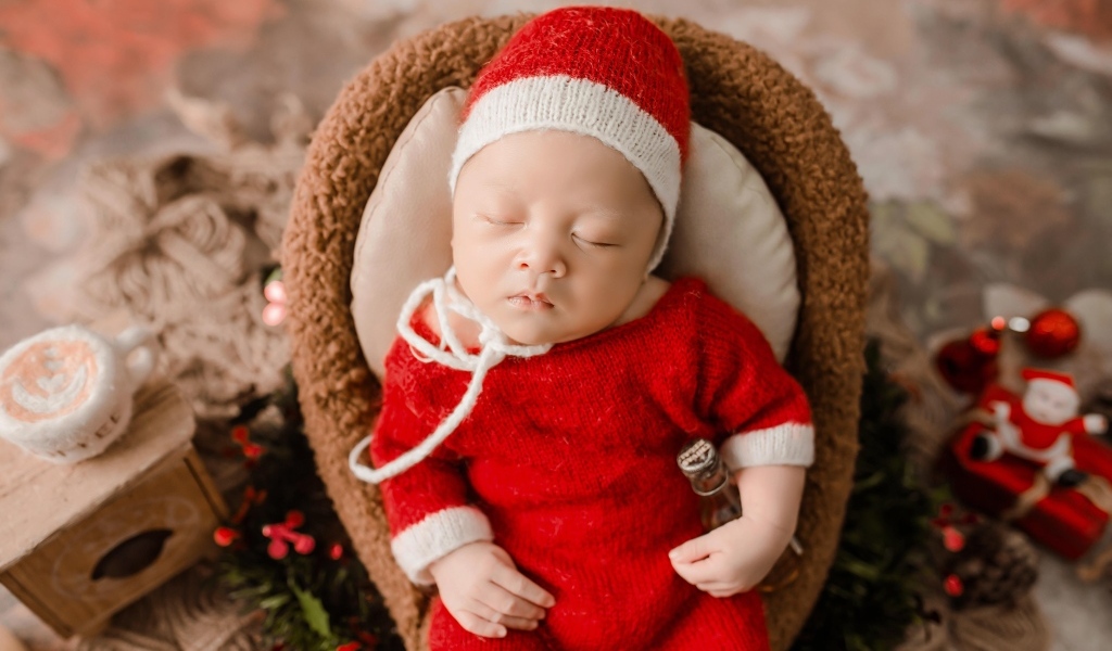 Новорожденный малыш в красном вязаном костюме