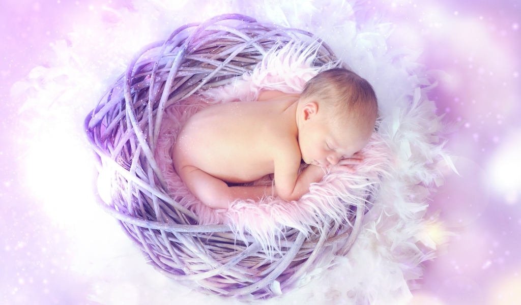Новорожденный ребенок спит в сиреневом гнезде