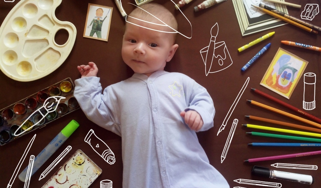 Новорожденный ребенок с канцелярскими предметами