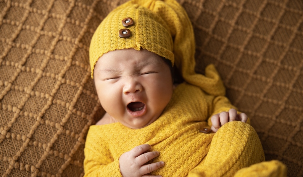 Новорожденный ребенок зевает во сне