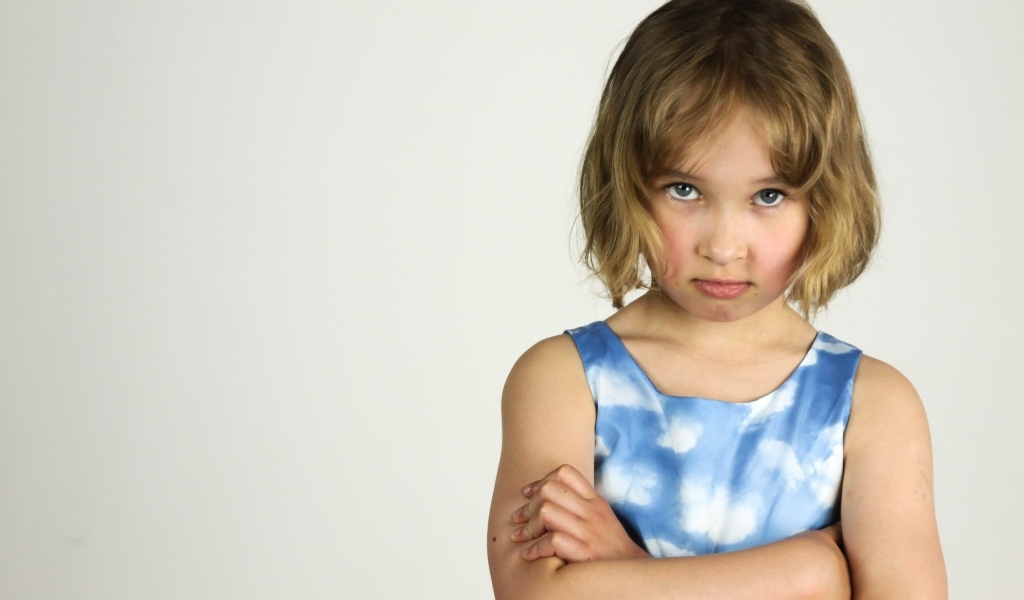 Серьезная девочка на сером фоне