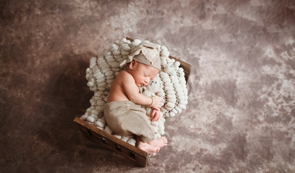 Спящий новорожденный ребенок в кроватке 