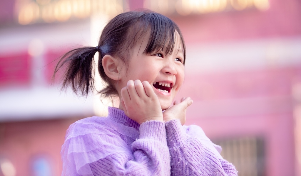 Улыбающаяся маленькая девочка азиатка в свитере
