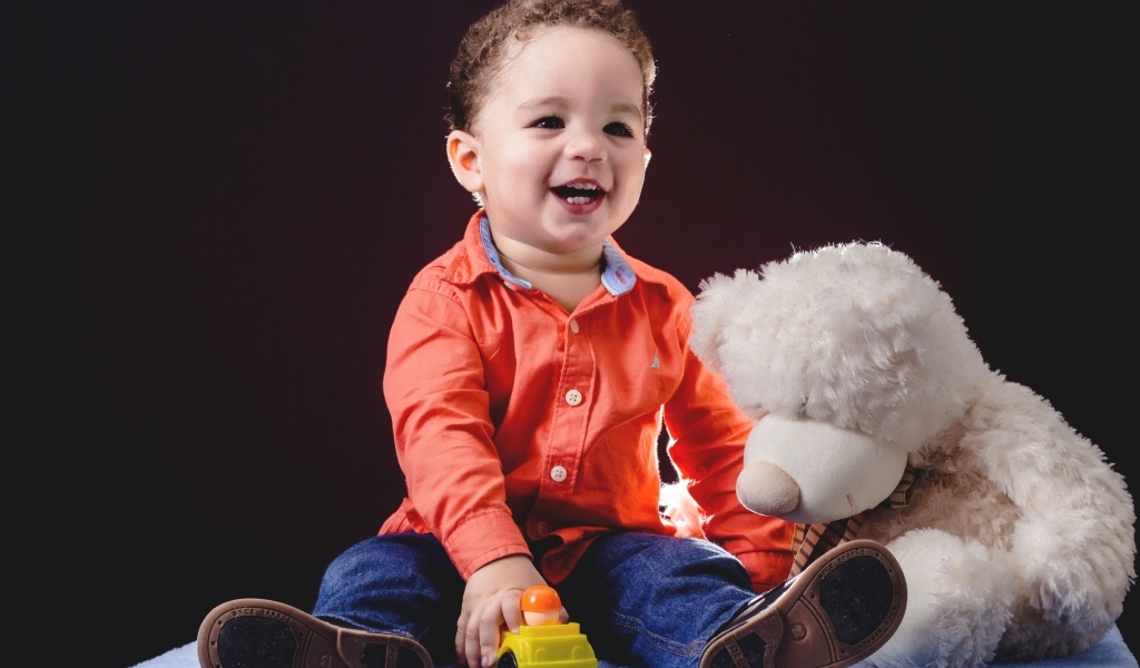 Улыбающийся мальчик с игрушечным медведем