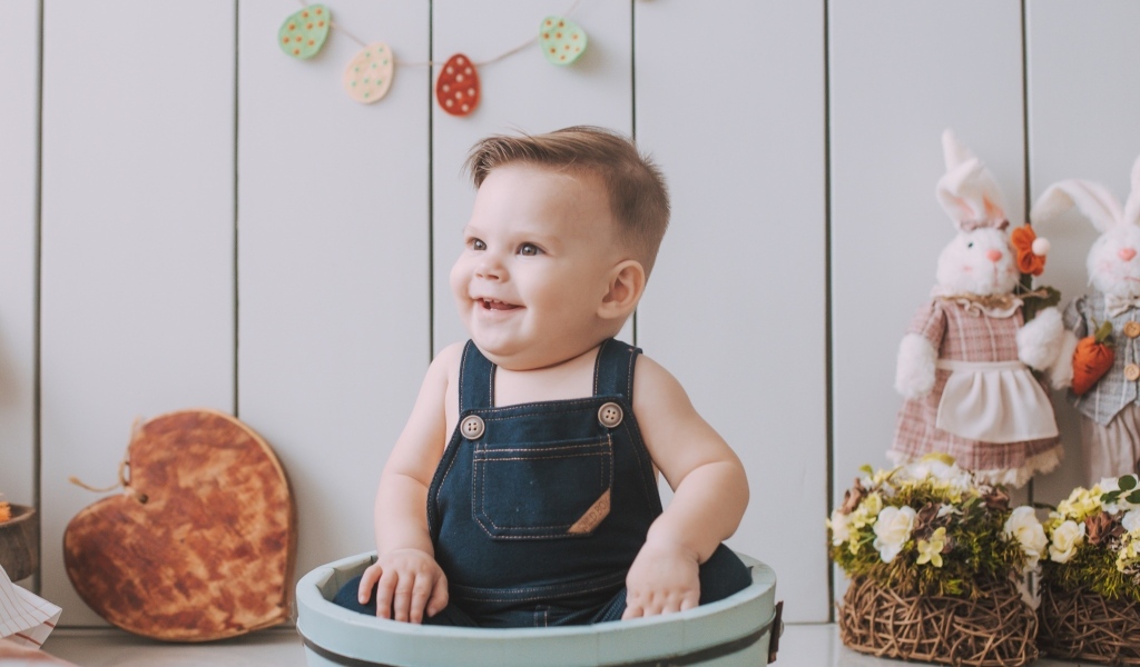 Улыбающийся ребенок сидит в ведре 