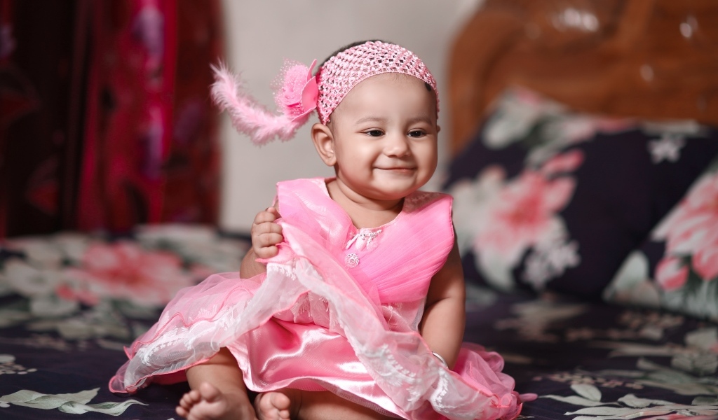 Улыбающаяся девочка в красивом розовом платье