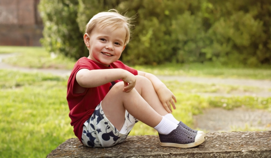 Улыбающийся маленький мальчик в красной футболке