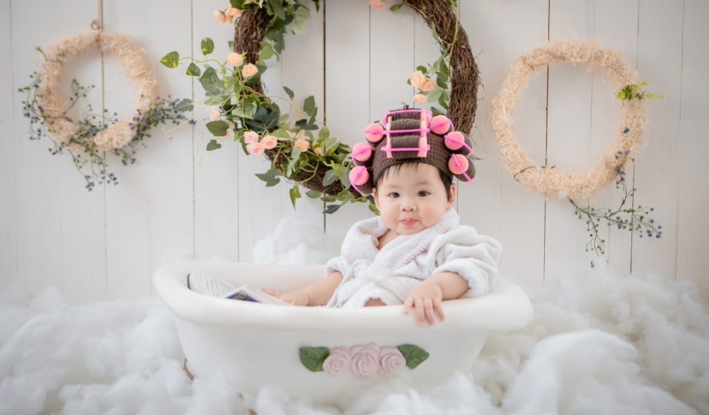 Ребенок сидит в ванной в халате