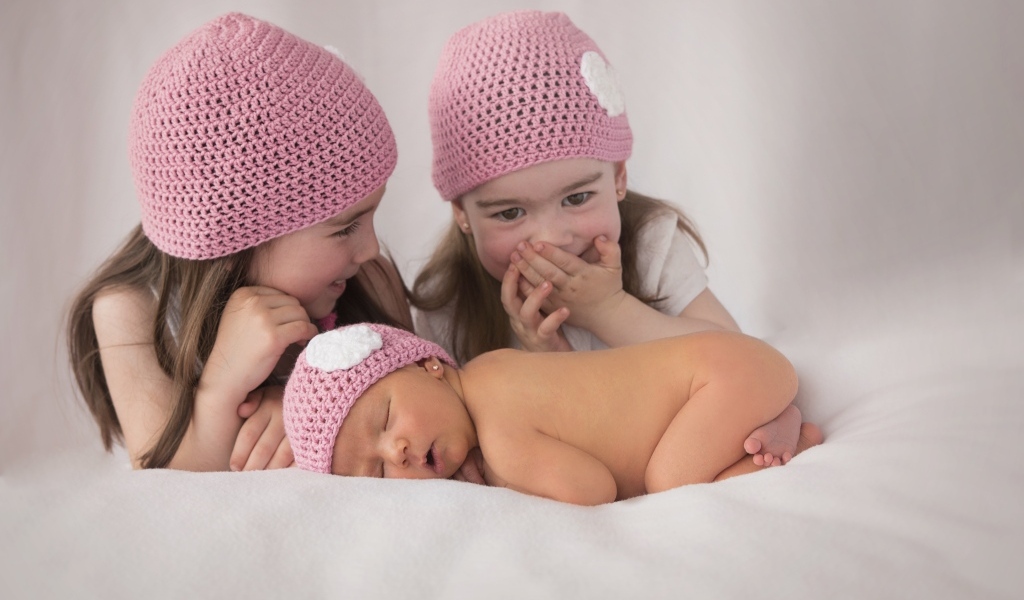 Три маленькие девочки в вязаных шапках