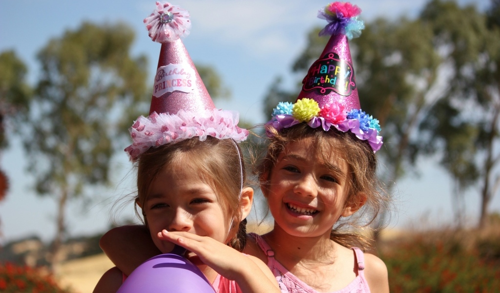 Две маленькие веселые девочки отмечают день рождения