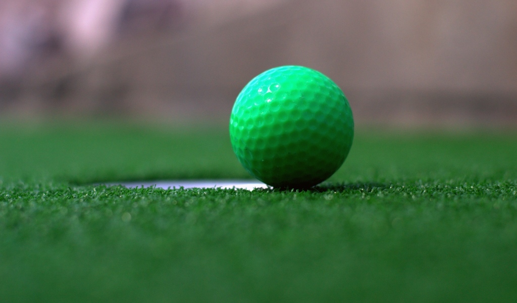 Зеленый мяч для игры в гольф на траве