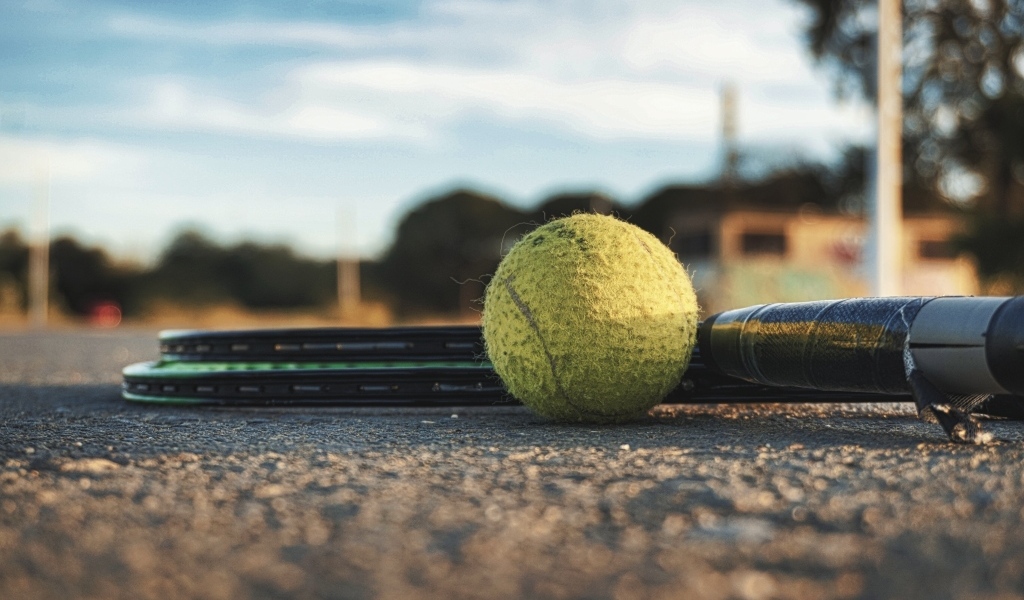 Старый теннисный мяч с ракетками