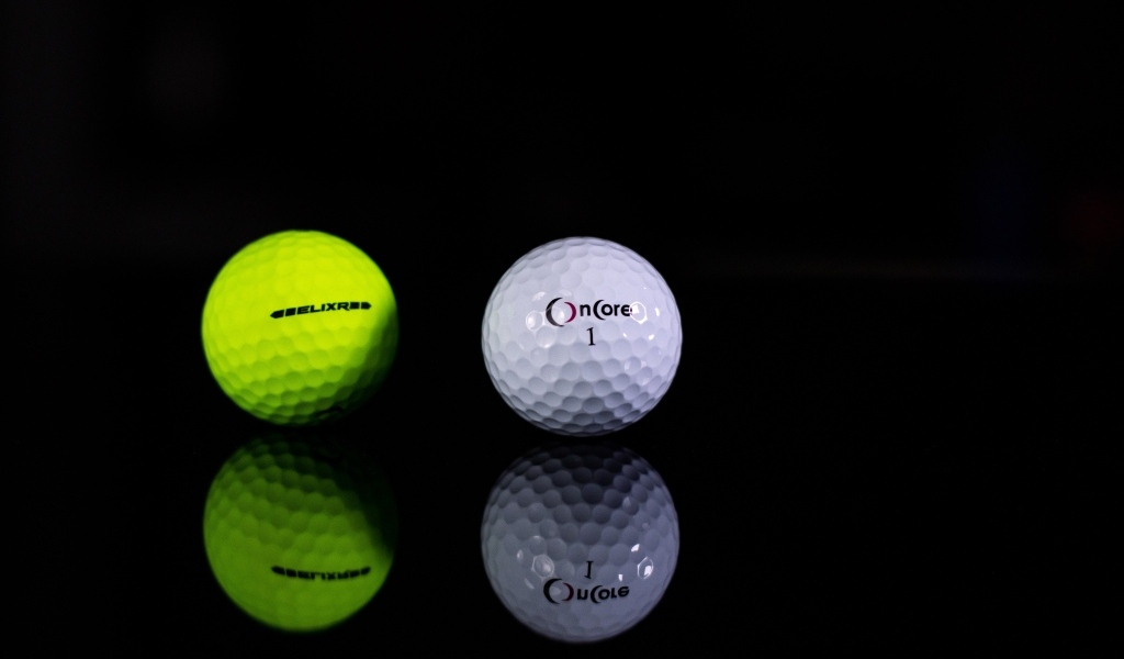 Два мяча для гольфа на черном фоне