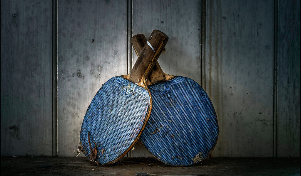 Две старые ракетки для настольного тенниса у стены