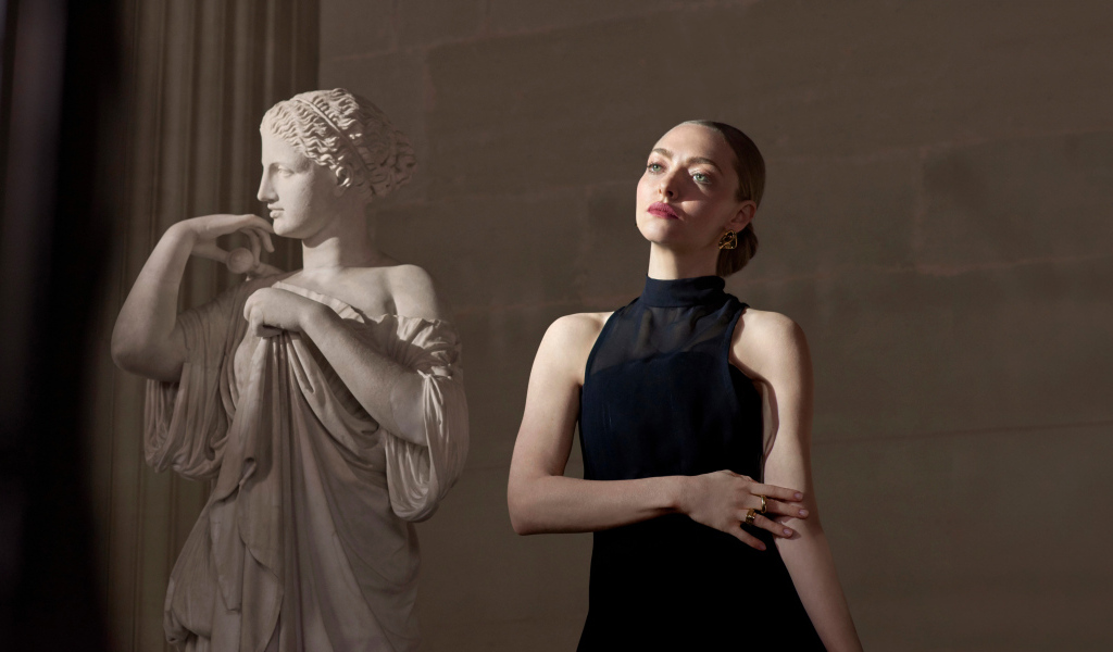 Актриса Аманда Сайфред в черном платье у статуи