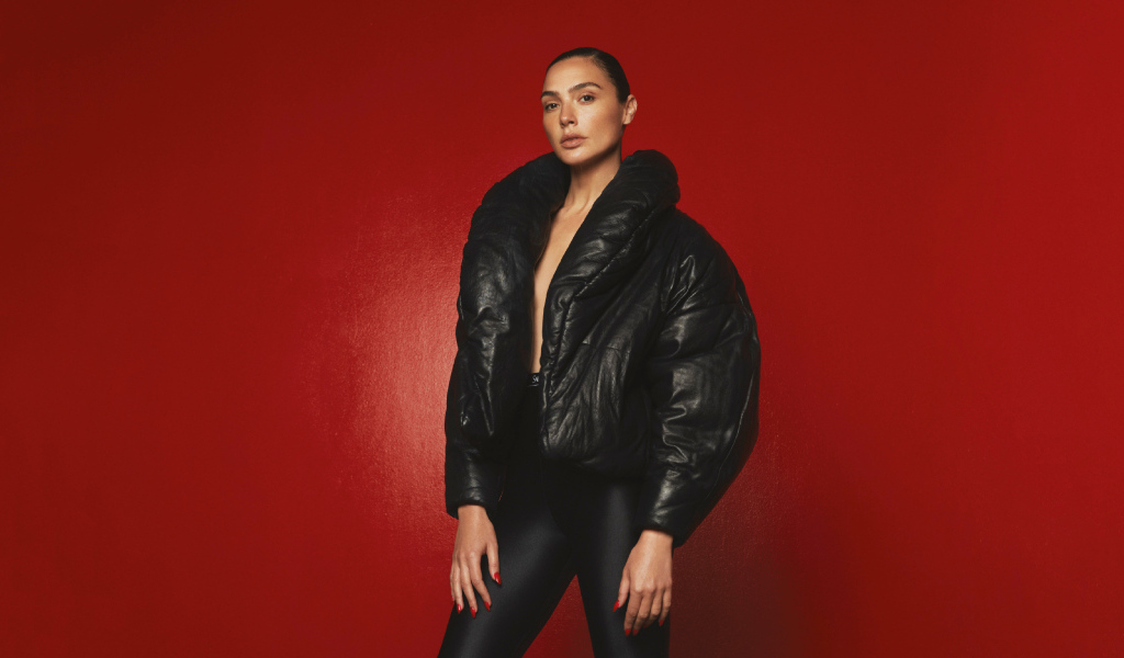 Актриса Галь Гадот в черной куртке на красном фоне