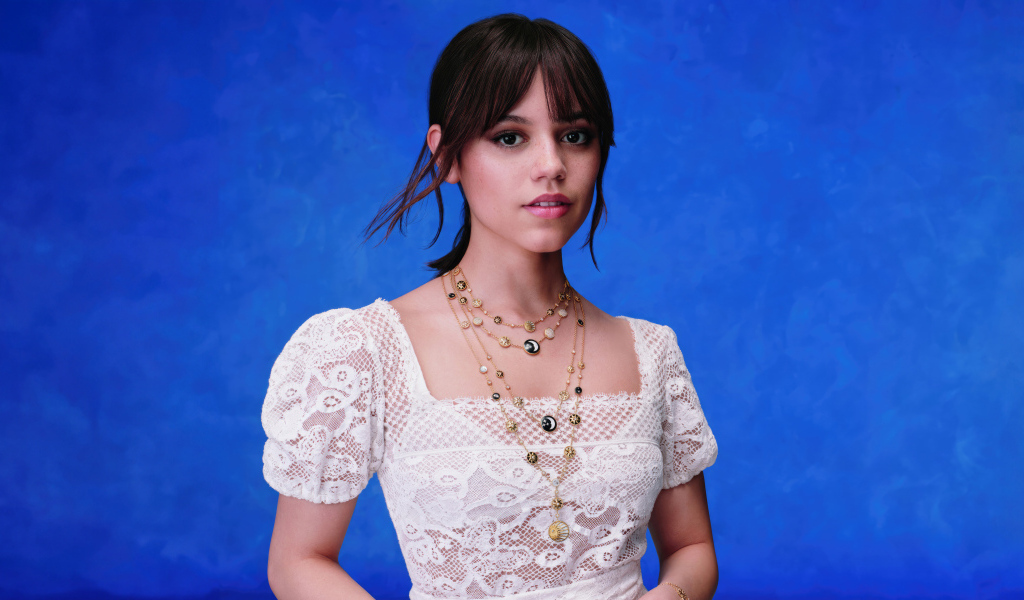 Actress Jenna Ortega in a white dress on a blue background