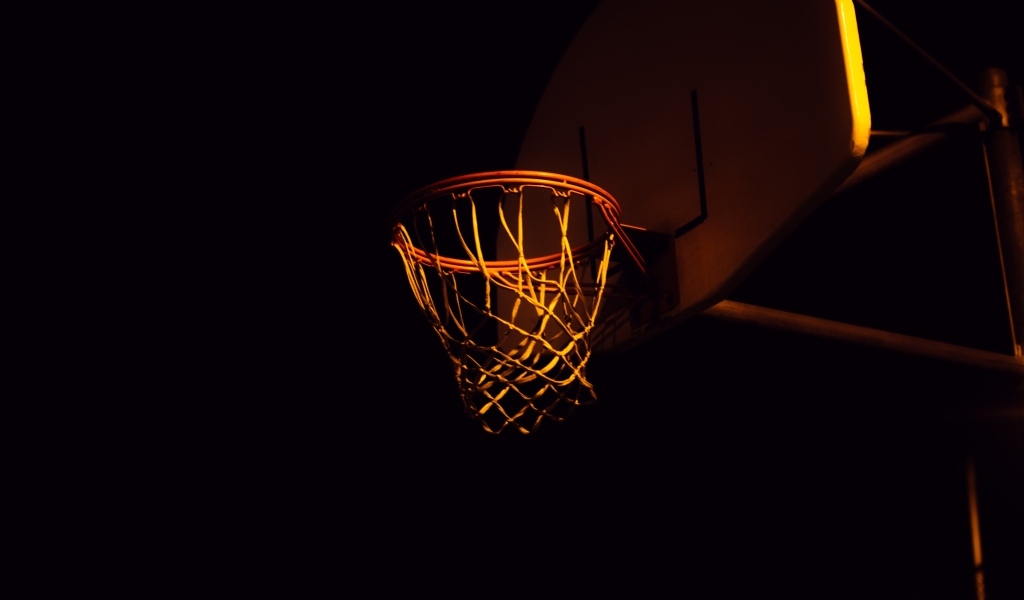 Баскетбольное кольцо в лучах света ночью