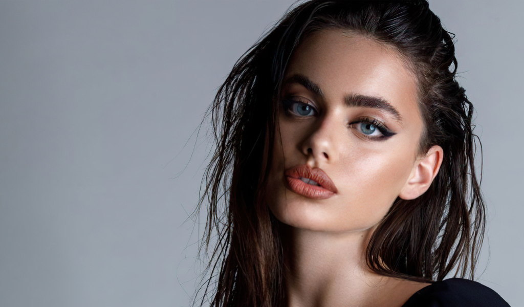 Красивая голубоглазая девушка Яэль Шелбиа на сером фоне