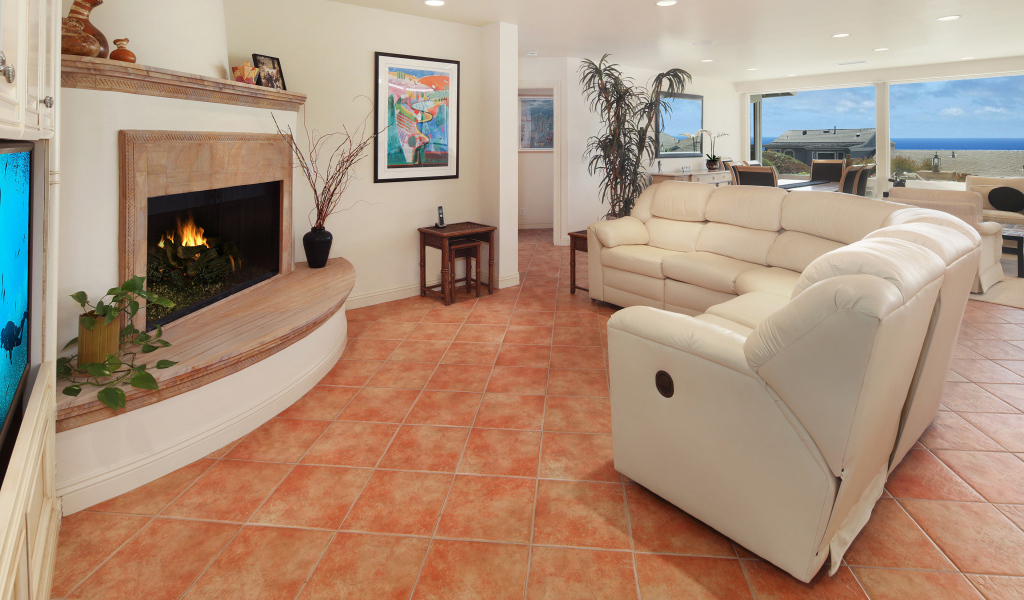 Красивый белый кожаный диван в гостиной с камином