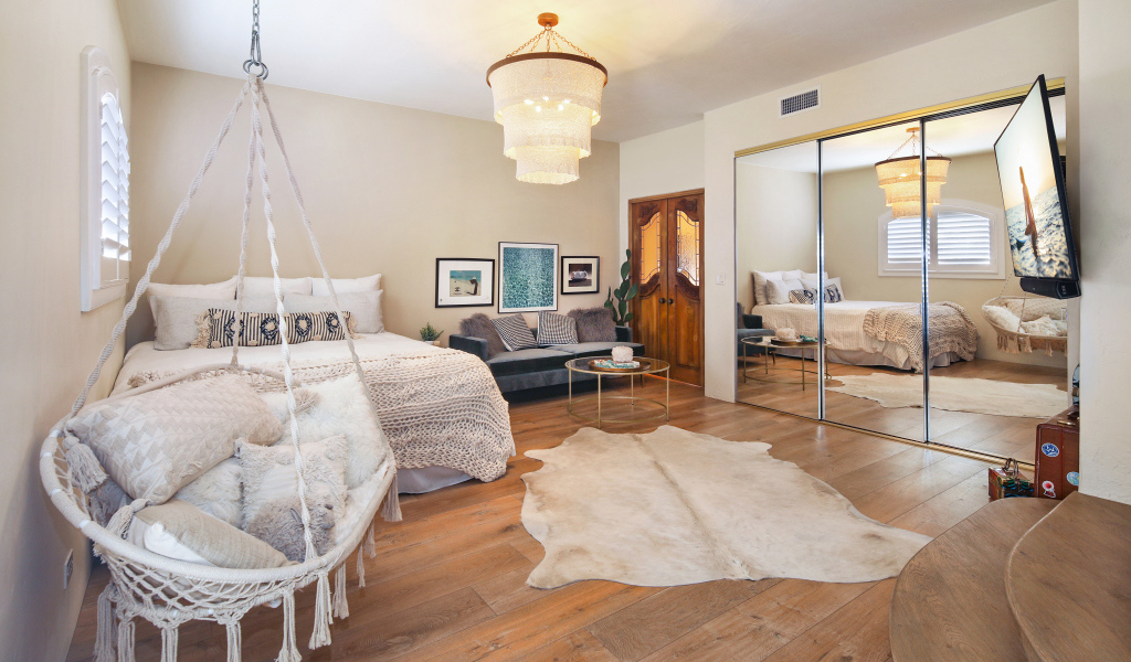 Спальня с белой кроватью и большим зеркалом