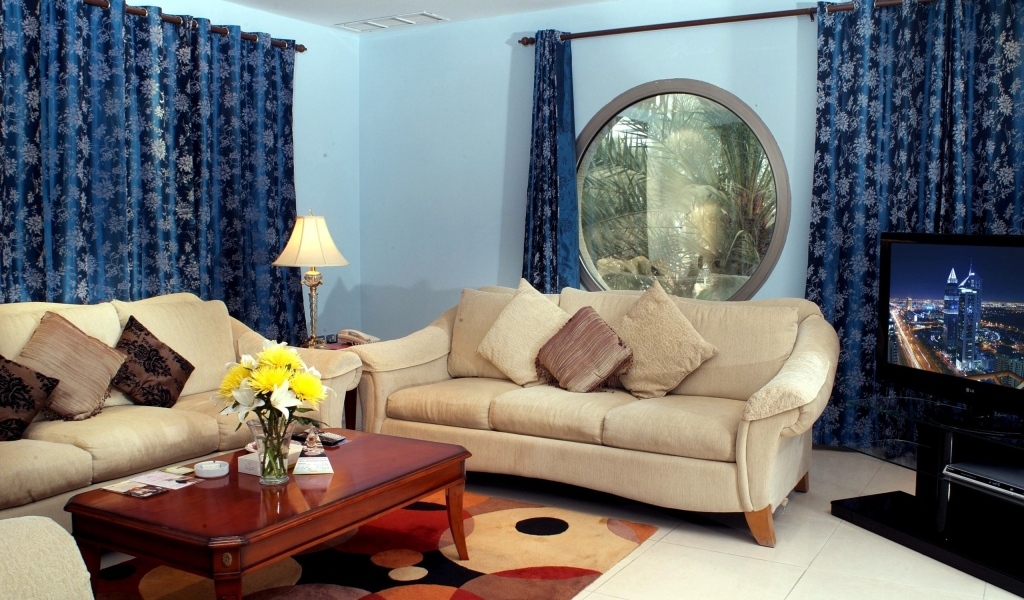 Синие шторы в гостиной с двумя диванами