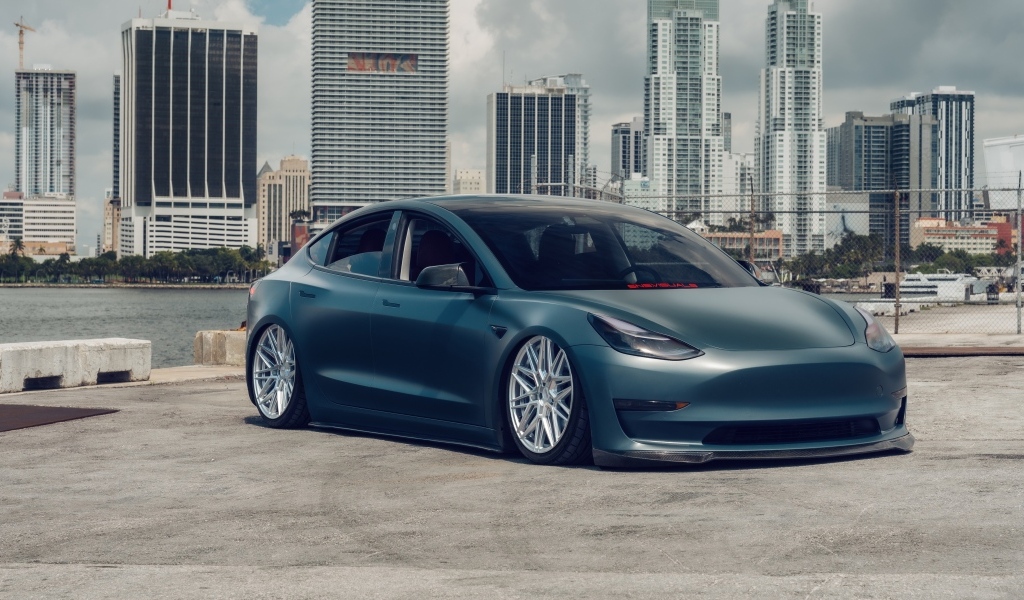 Электрокар Tesla Model 3 на фоне небоскребов