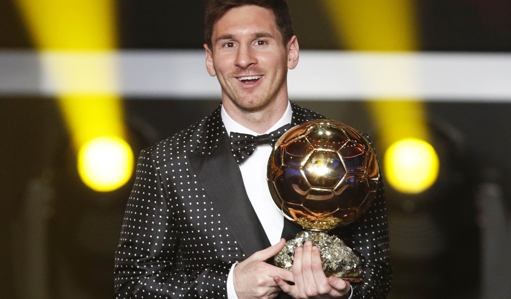 Футболист Лионель Месси с золотым мячом в руках