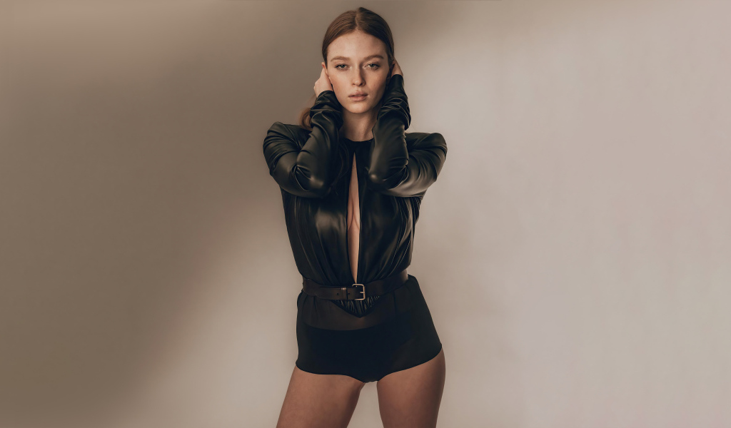 Девушка Ларсен Томпсон в черном костюме у стены