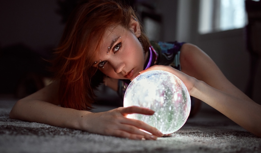 Девушка с пирсингом держит волшебный шар