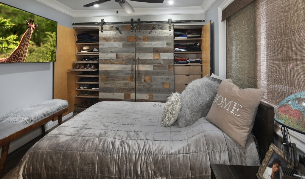 Большая мягкая кровать в спальне со шкафом