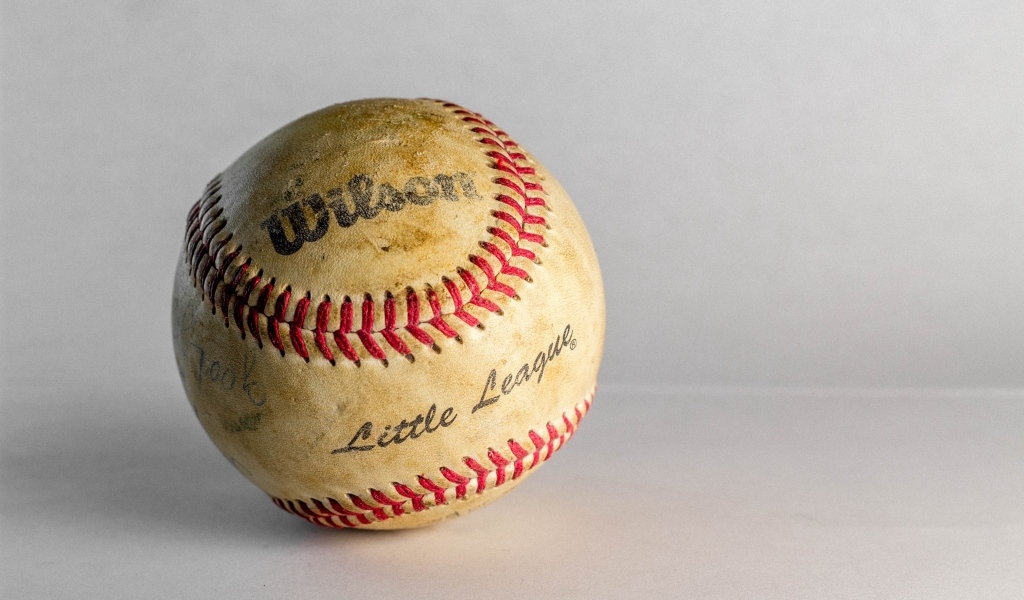 Старый бейсбольный мяч на сером фоне